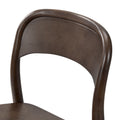 Close-up of dark brown solid wood bentwood dining chair back with curved walnut-finish backrest and visible wood grain