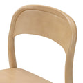 Close-up of curved natural beech wood dining chair backrest showing smooth grain and modern Scandinavian design