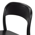 Close-up of a black bentwood dining chair showing curved backrest, smooth painted frame and visible wood grain finish