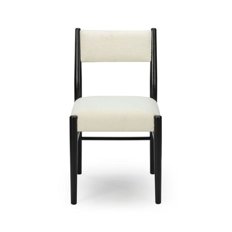 Modern minimalist dining chair with cream upholstered seat and back and black wooden frame, front view on white background
