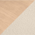 Close-up of light oak hardwood floor meeting beige textured carpet at a diagonal flooring transition