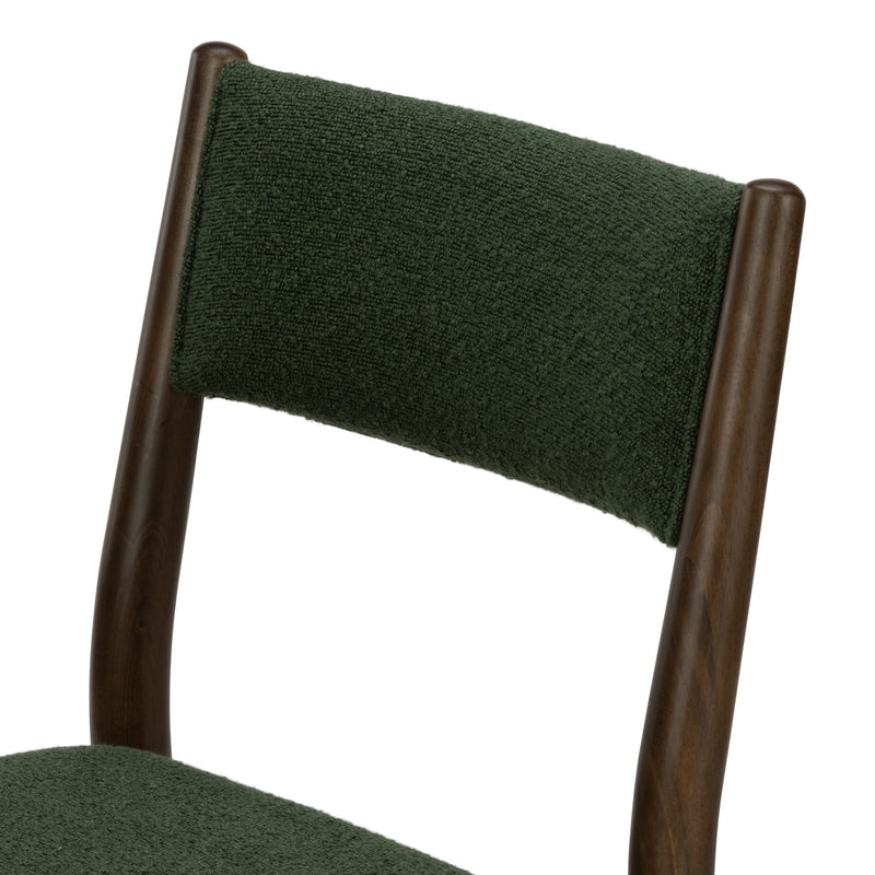 Close-up of dark green textured upholstered dining chair back with dark walnut wooden frame
