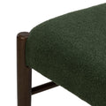 Close-up of green boucle upholstered chair seat with dark walnut wooden frame, textured fabric detail for mid-century modern dining or accent chair