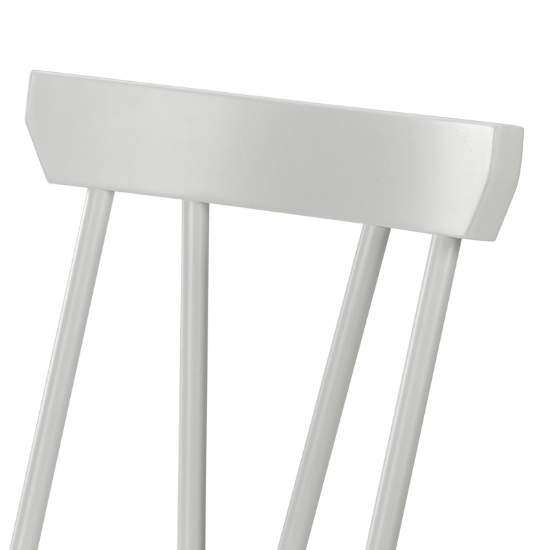 Close-up of white painted spindle-back wooden dining chair showing curved top rail and vertical spindles, modern farmhouse style