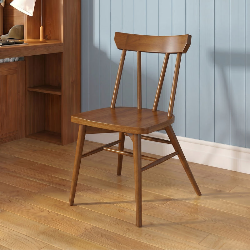 Natural wood spindle-back chair on hardwood floor beside built-in wooden desk and light blue paneled wall in modern rustic interior