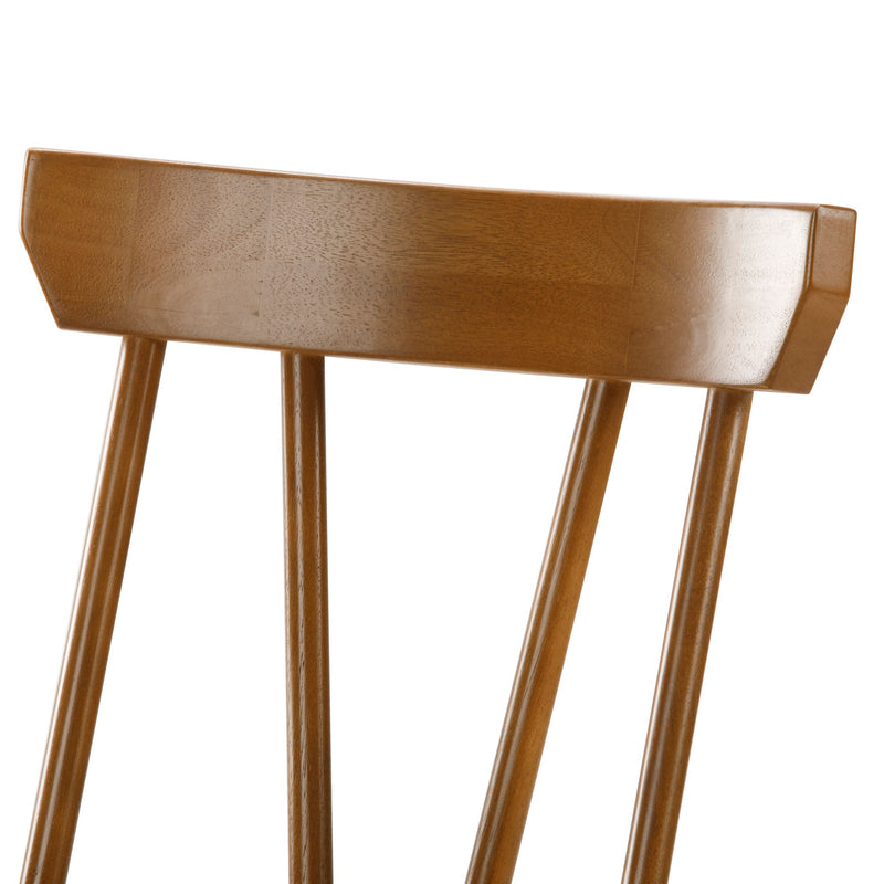 Close-up of a brown mid-century modern wooden dining chair back showing spindle slats and smooth wood grain finish