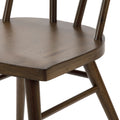 Close-up of dark brown wooden bar stool seat and spindle back showing round seat, tapered legs and crossbar stretchers