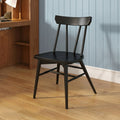 Black wooden chair against light blue paneled wall beside walnut desk on hardwood floor