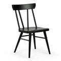Matte black wooden spindle-back dining chair with rounded seat and tapered legs, mid-century modern kitchen chair on white background