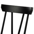 Close-up of black wooden dining chair backrest with spindle back, matte painted finish, modern farmhouse style