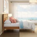 Coastal bedroom with ocean view, wooden bed frame, pastel throw pillows, sheer curtains and beach-facing window letting in natural light