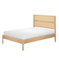 Natural oak wood platform bed frame with woven cane rattan headboard and white mattress, modern Scandinavian minimalist bedroom furniture