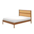 Mid-century modern wooden platform bed with woven rattan headboard panels and white mattress on a white background