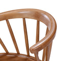 Close-up of a mid-century modern wooden Windsor chair back with curved oak armrest and vertical spindles, smooth natural wood finish