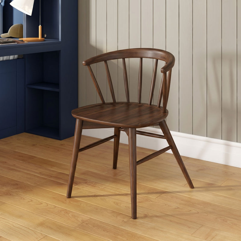Home office scene: dark wood spindle-back chair beside navy built-in desk with orange lamp, beige shiplap wall and hardwood floor
