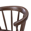 Dark brown wooden dining chair back close-up showing curved solid-wood backrest and vertical spindles with smooth stained finish