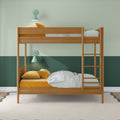 Modern wooden bunk bed in children's room with green two-tone walls, mustard velvet pillows, striped sheets, ladder and mint wall lamps