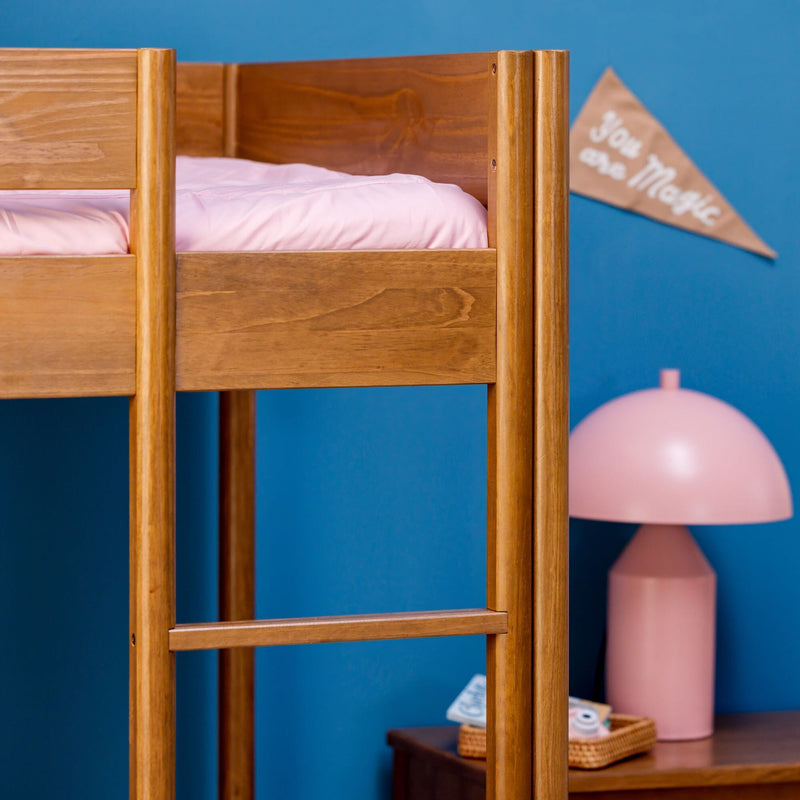 Solid wood bunk bed with pink bedding against a blue nursery wall, pink table lamp and "You Are Magic" banner, modern kids' room decor