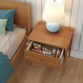 Mid-century modern wooden bedside table with blue ceramic lamp and open drawer of pastel wooden children's toys in a striped nursery bedroom