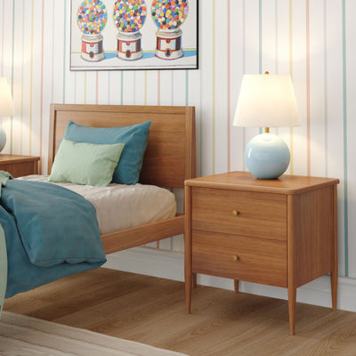 Mid-century wooden nightstand (bedside table) with blue lamp next to teal bedding and wooden bed, pastel striped wallpaper and gumball artwork