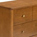 Mid-century modern wooden dresser close-up showing warm walnut finish and round brass drawer knobs
