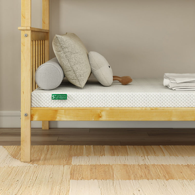 5-inch gel memory foam mattress on light wooden twin bed frame with textured cream pillows, bolster and folded white sheets in a minimalist beige bedroom