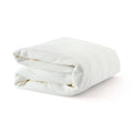 Folded white waffle-knit cotton blanket on white background — soft, breathable, hypoallergenic bed blanket for home