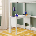 White loft bed with built-in study desk, blue desk lamp, Rubik-style cube, mug of colored pens, stacked books, sage green wall, beige curtains and yellow rug