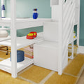 White loft bunk bed with built-in desk and shelves, blue mug of colorful pens, red toy car, stacked books and yellow rug in children's room
