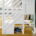 White wooden kids' loft bunk bed with diagonal slat railing, built-in storage shelf, blue sneakers, yellow wire basket and succulent on mustard rug against green wall
