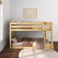 Wooden bunk bed in a neutral kids' bedroom with pink-beige bedding, ladder, round knit rug and framed daisy wall art