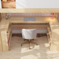 Cozy home office study nook with built-in light wood desk, closed MacBook laptop, white swivel chair, pink desk lamp and headphone stand