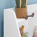 Nursery shelf with smiling woven fabric planter, faux plant, wooden animal toys and pastel stacking rings — modern kids room decor