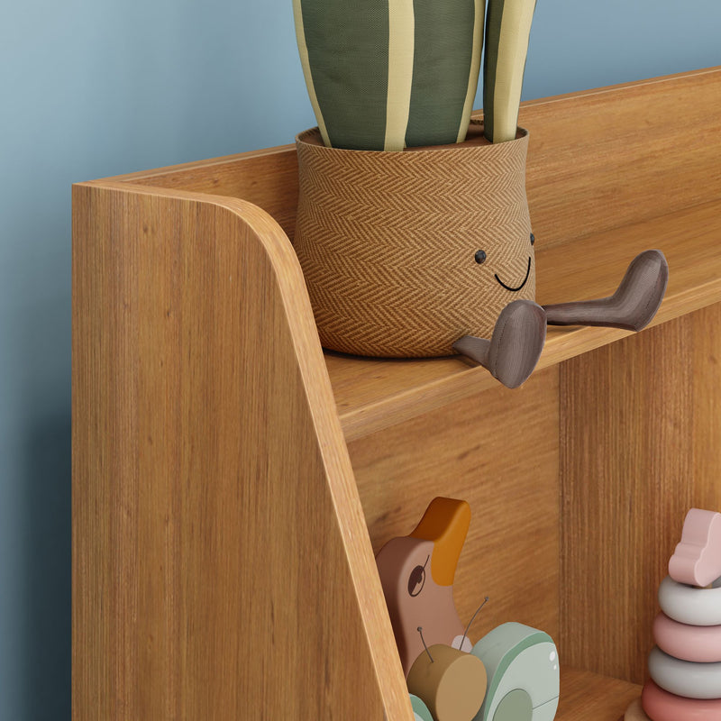 Nursery wooden shelf with smiling woven plant pot holding green striped leaves, pastel stacking rings and wooden animal toys against a blue wall